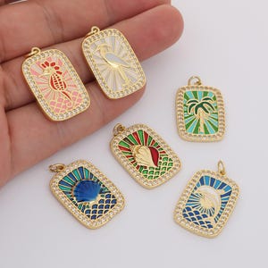 Puede incluir: Colgantes rectangulares dorados con diseños de esmalte colorido. Los colgantes presentan imágenes de un caballito de mar, un pájaro, una palmera, una concha, una concha y un delfín. Cada colgante está delineado con pequeños cristales transparentes.
