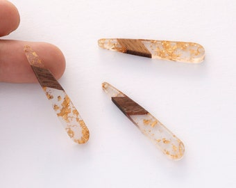 Puede incluir: Tres pinzas para el pelo de resina transparente con detalles de pan de oro y una incrustación de madera marrón.
