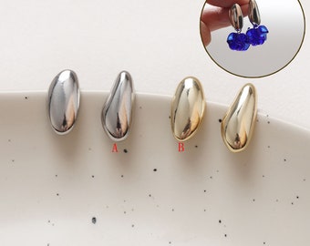 May include: Three pairs of earrings in different finishes: silver, gold, and a brushed silver. The earrings are shaped like a teardrop.