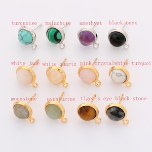 Könnte beinhalten: Eine Sammlung von Ohrsteckern mit verschiedenen Edelsteinen, darunter Türkis, Malachit, Amethyst und schwarzer Onyx. Jeder Ohrring hat eine goldfarbene Lünette und einen Stecker für durchbohrte Ohren. Das Bild zeigt auch Ohrringe mit weißem Jade, weißem Quarz, rosa, kristallweiß, Mondstein, Aventurin, Tigerauge und schwarzem Stein.