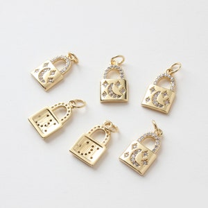 May include: Six gold-tone padlock charms with clear crystal embellishments. Some charms feature a crescent moon and stars design, while others have a geometric pattern.