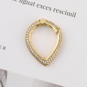 May include: Gold-toned teardrop-shaped ring with a clear crystal pave setting.