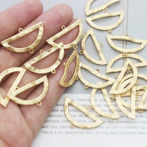 Peut inclure: Une collection de demi-cercles en m&eacute;tal dor&eacute; avec une texture martel&eacute;e. Chaque forme a deux petites boucles en haut.