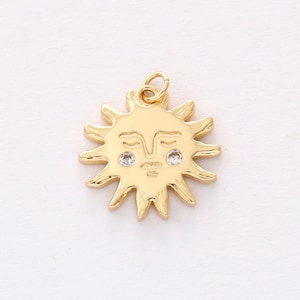 May include: Gold sun charm with a face and two small clear rhinestones for eyes.