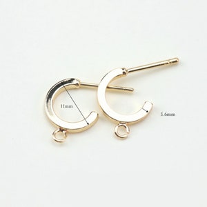 Puede incluir: Dos aros de pendientes dorados con un anillo de salto y un poste. El aro tiene un di&aacute;metro de 11 mm y un ancho de 1,6 mm.