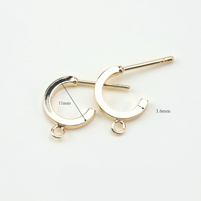 Puede incluir: Dos aros de pendientes dorados con un anillo de salto y un poste. El aro tiene un di&aacute;metro de 11 mm y un ancho de 1,6 mm.