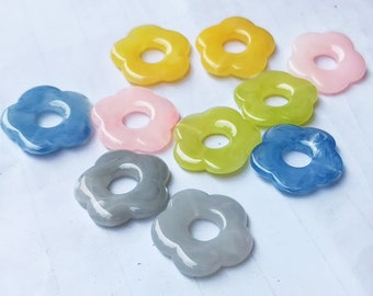 May include: Assortment of colorful flower-shaped resin beads with a hole in the center. The beads are in shades of blue, pink, yellow, and gray.