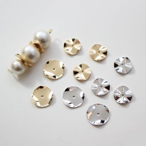 May include: A collection of gold and silver metal embellishments with a wavy texture. The embellishments are round and have a hole in the center. They are perfect for adding a touch of elegance to any craft project.