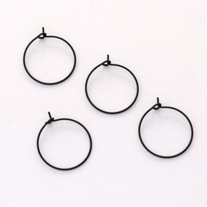 May include: Four black hoop earrings, each with a simple, circular design.