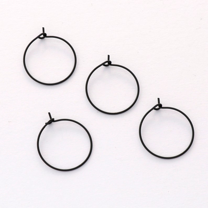 May include: Four black hoop earrings, each with a simple, circular design.