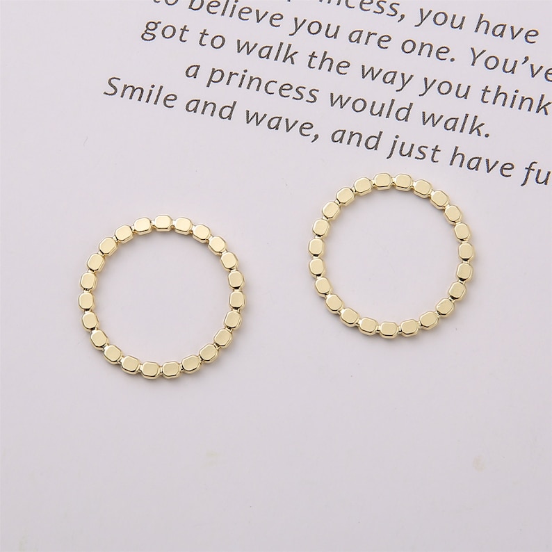 Puede incluir: Dos anillos de oro hechos de peque&ntilde;as cuentas cuadradas conectadas.