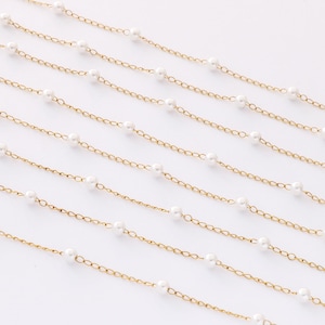 May include: Multiple strands of gold chain with white pearl beads. The chains are arranged in a staggered pattern on a white background.
