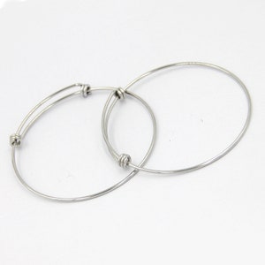 May include: Two silver bangle bracelets with knotted accents.