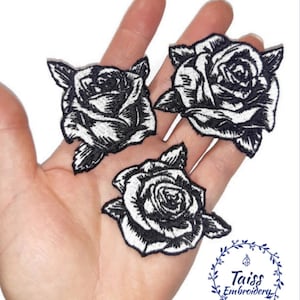 May include: Three black and white embroidered rose patches. Each patch features a detailed rose design with petals and leaves. The patches are displayed on a light background. The text "Taiss Embroidery" is in the lower right corner.