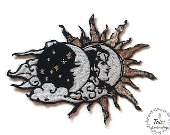 May include: Embroidered iron-on patch featuring a sun and moon design. The sun is gold and has rays. The moon is silver and has a face. The background is black with white stars.