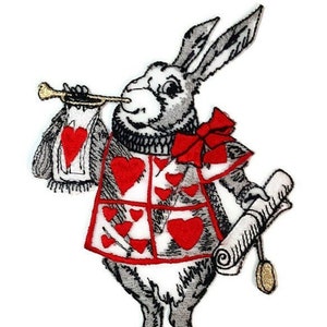 May include: Embroidered patch of the White Rabbit from Alice in Wonderland. He is wearing a red and white suit with hearts and holding a trumpet and a scroll.