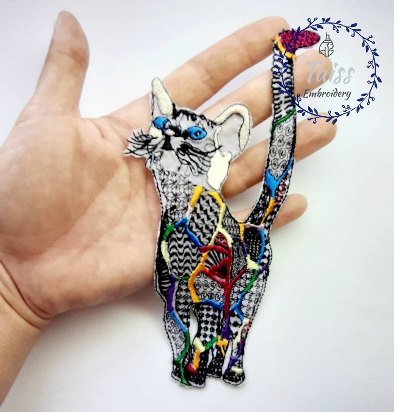 May include: A colorful embroidered iron-on patch of a cat with a white background. The cat is outlined in black and has a variety of colorful details throughout the design. The cat's tail is curled up behind its back.