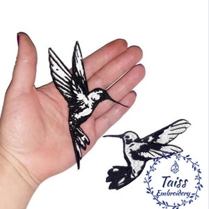 Puede incluir: Dos parches bordados de colibrí en blanco y negro. Los parches se muestran en una mano para referencia de tamaño. Los parches son para coser o planchar sobre tela.
