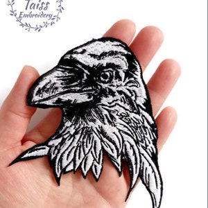 May include: Black and white embroidered iron-on patch of a raven's head.