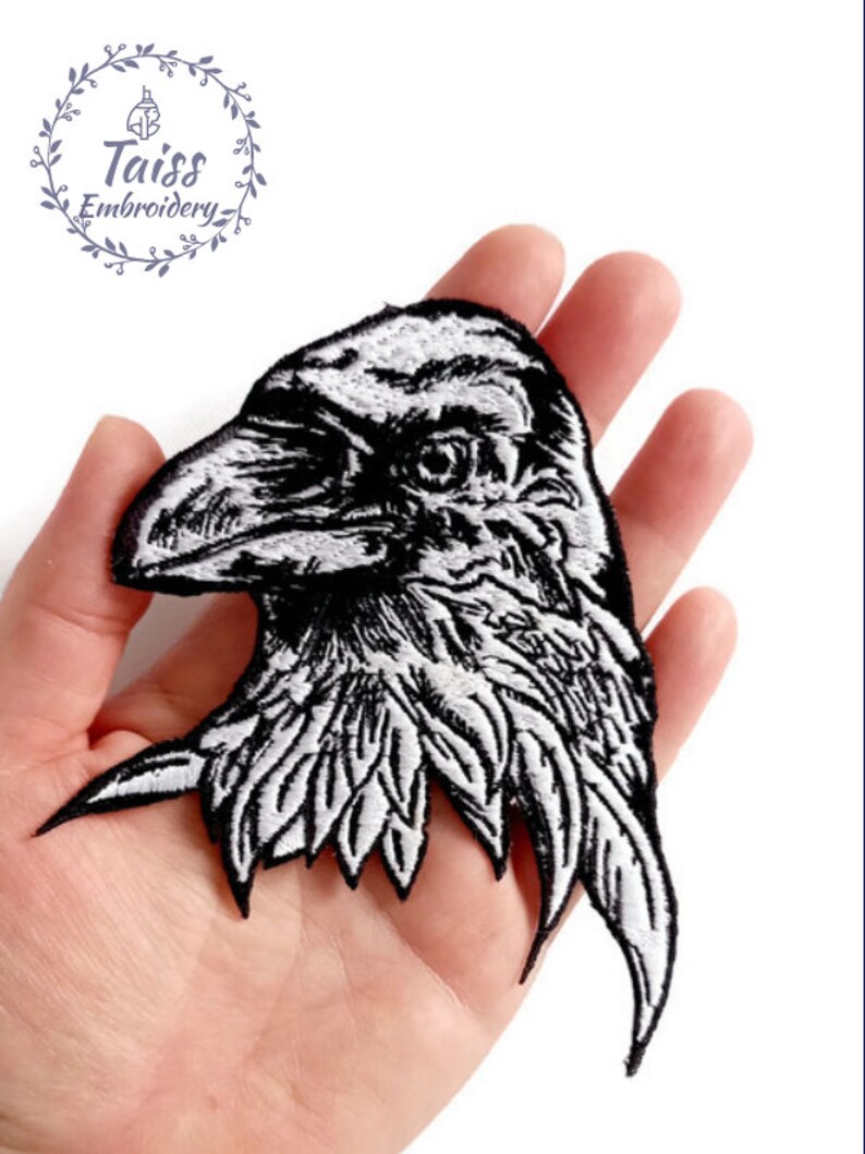 May include: Black and white embroidered iron-on patch of a raven's head.