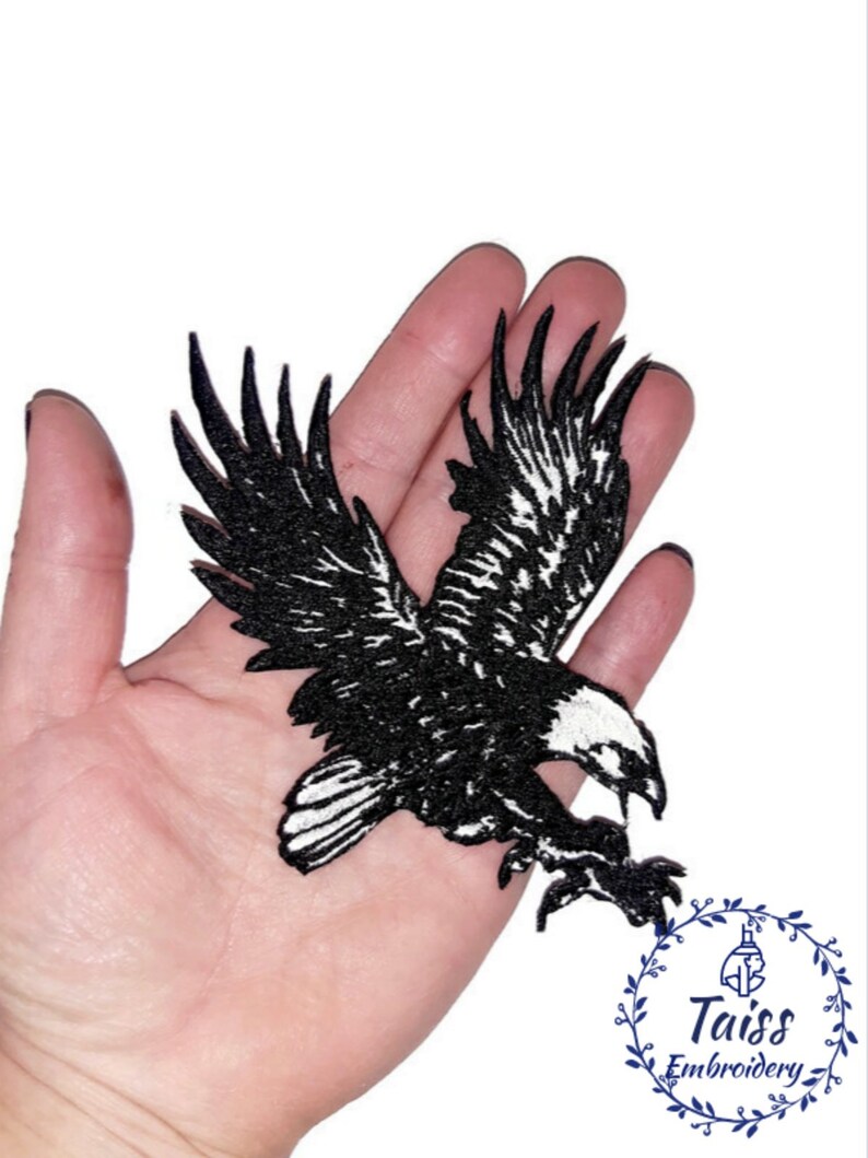 Puede incluir: Parche de hierro bordado en blanco y negro de un &aacute;guila en vuelo. El &aacute;guila se muestra con las alas extendidas y las garras extendidas. El parche mide aproximadamente 10 cm de ancho.