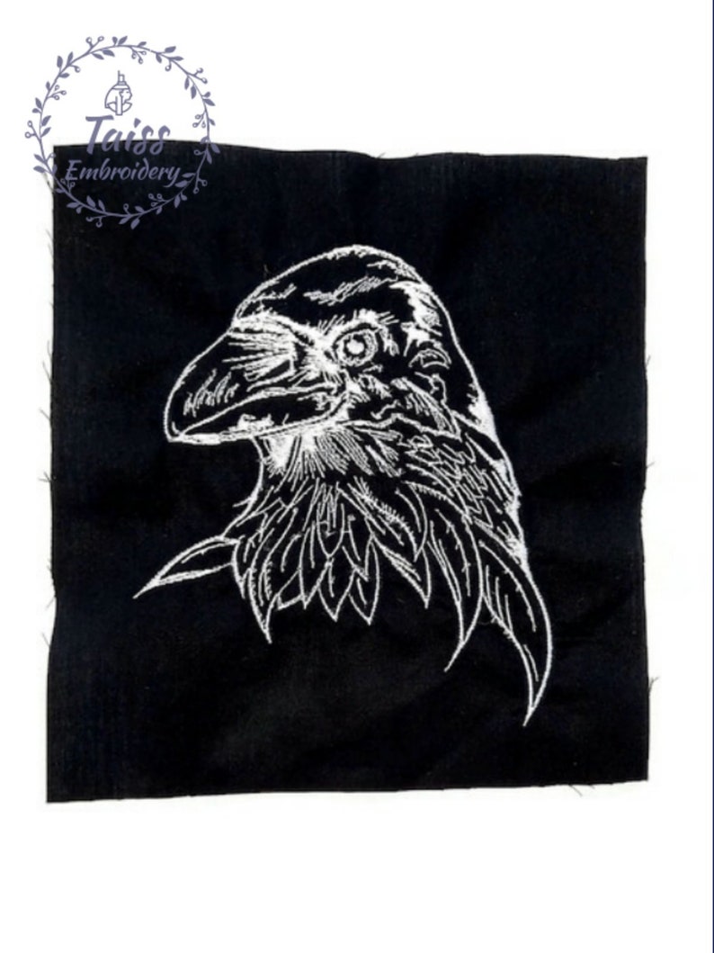 May include: White embroidered raven head on a black fabric background.