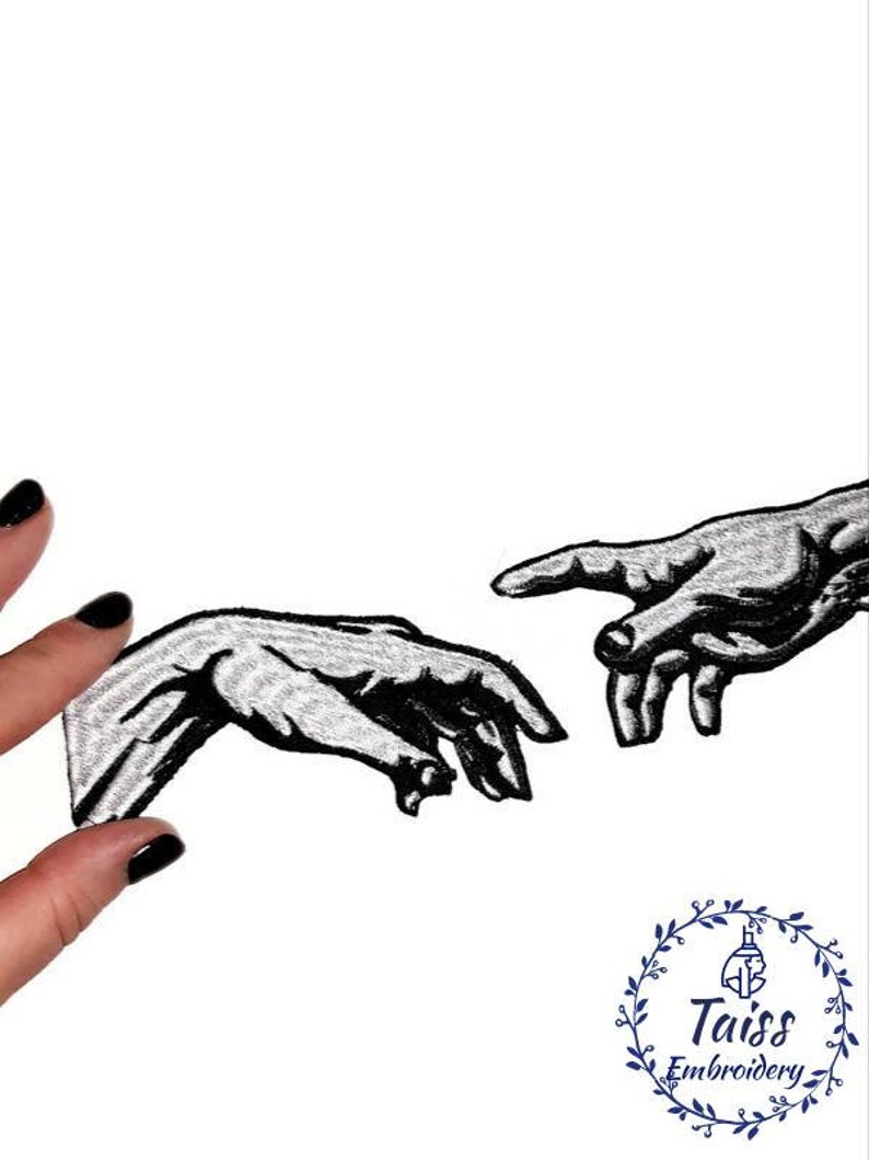 Pu&ograve; includere: Toppa ricamata in bianco e nero di due mani che si raggiungono, ispirata alla Creazione di Adamo di Michelangelo. La toppa &egrave; su uno sfondo bianco ed &egrave; tenuta da una mano con smalto nero.