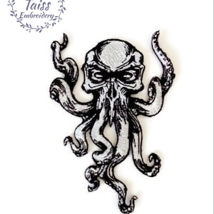 May include: Black and white embroidered patch depicting a skull with tentacles, resembling an octopus. The skull has a menacing expression with large eyes and an open mouth.