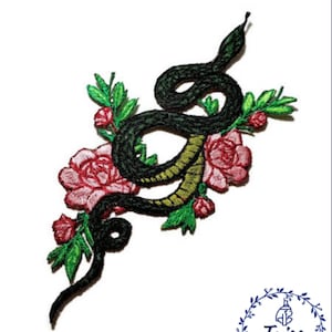 May include: Embroidered iron-on patch featuring a green snake wrapped around pink flowers. The snake has a yellow underbelly and the flowers have green leaves.