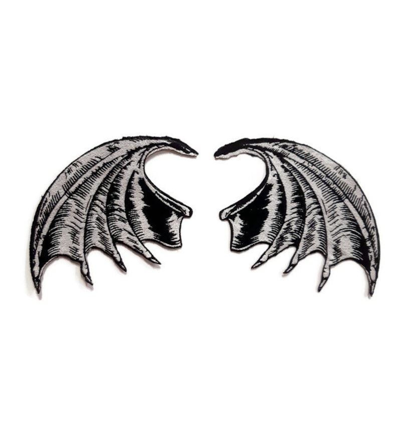 K&ouml;nnte beinhalten: Zwei gestickte B&uuml;geleisen-Aufn&auml;her, die ein Paar D&auml;monenfl&uuml;gel in Schwarz und Silber darstellen.