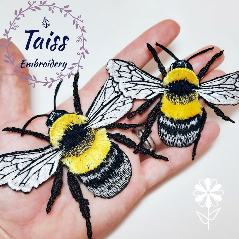Pu&ograve; includere: Due toppe ricamate di bombi con strisce nere e gialle, ali bianche e zampe nere. I bombi sono su una mano.