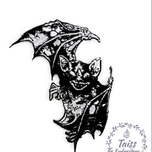 May include: Black and white embroidered iron-on patch of a bat with its wings spread out. The bat has a menacing expression and sharp teeth. The patch is ideal for adding a spooky touch to clothing, bags, or other accessories.
