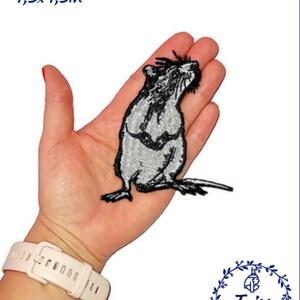May include: A black and white embroidered iron-on patch of a rat, measuring 11cm by 11cm. The patch is on a hand for size reference.