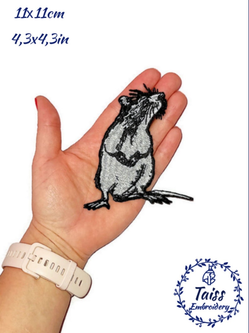 May include: A black and white embroidered iron-on patch of a rat, measuring 11cm by 11cm. The patch is on a hand for size reference.