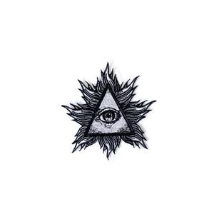 May include: A black and white patch depicting the all-seeing eye inside a triangle, encircled by stylized flames. This patch, a symbol of the Illuminati, is suitable for application on jackets, bags, or other fabric items.