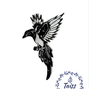 Puede incluir: Parche de hierro bordado en blanco y negro de un pájaro en vuelo. El pájaro tiene una cola larga y alas extendidas. El parche es perfecto para agregar un toque de fantasía a la ropa, bolsos u otros artículos de tela.