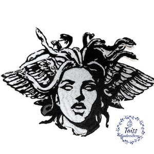 May include: Black and white embroidered patch of Medusa, a mythical Greek figure with snakes for hair, wings, and a human face. The patch is on a white background.