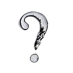 May include: A white embroidered question mark with a skull design. The question mark is outlined in black.