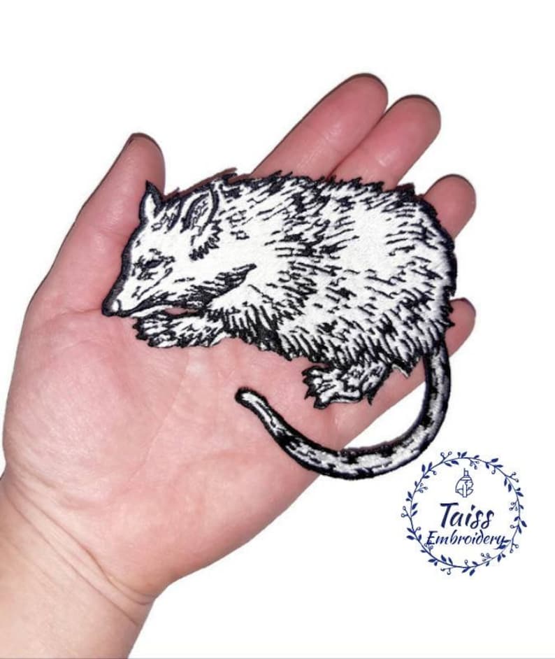 May include: Black and white embroidered iron-on patch of a sleeping mouse. The patch is approximately 7.5 cm wide and 5 cm tall.
