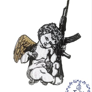 Könnte beinhalten: Ein gestickter Aufnäher mit einem Cherub, der ein Gewehr hält. Der Cherub hat einen weißen Körper, schwarze Haare und goldene Flügel. Das Gewehr ist schwarz mit einem silbernen Lauf. Der Aufnäher befindet sich auf einem weißen Hintergrund.