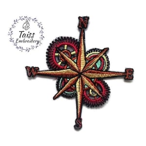 Könnte beinhalten: Ein gestickter Bügel-Patch mit einer roten, goldenen und grünen Kompassrose mit Zahnrädern. Die Kompasspunkte sind mit N, S, E und W gekennzeichnet.