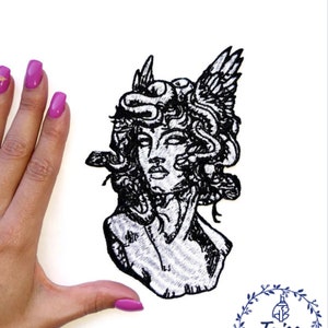 Könnte beinhalten: Schwarz-weiß gestickter Patch eines Frauenbüsten mit Schlangen und Flügeln. Der Patch befindet sich auf einem weißen Hintergrund.