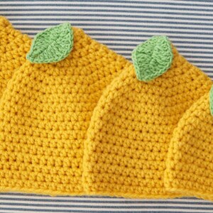 Puede incluir: Cuatro gorros de punto de lim&oacute;n en diferentes tama&ntilde;os, con hojas de fieltro verde en la parte superior. Los gorros son amarillos y tienen un patr&oacute;n de punto texturizado.