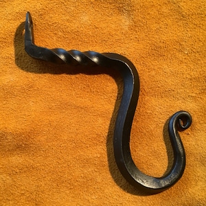 May include: A black metal hook with a twisted design. The hook is shaped like a letter 'S' with a small loop at the top.