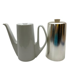 May include: A white ceramic coffee pot with a silver metal coffee pot next to it.