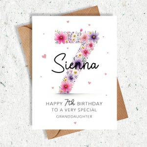 May include: A birthday card with a floral number seven design. The number is filled with pink and purple flowers. The name "Sienna" is written in black script. The card reads "Happy 7th Birthday to a very special granddaughter."