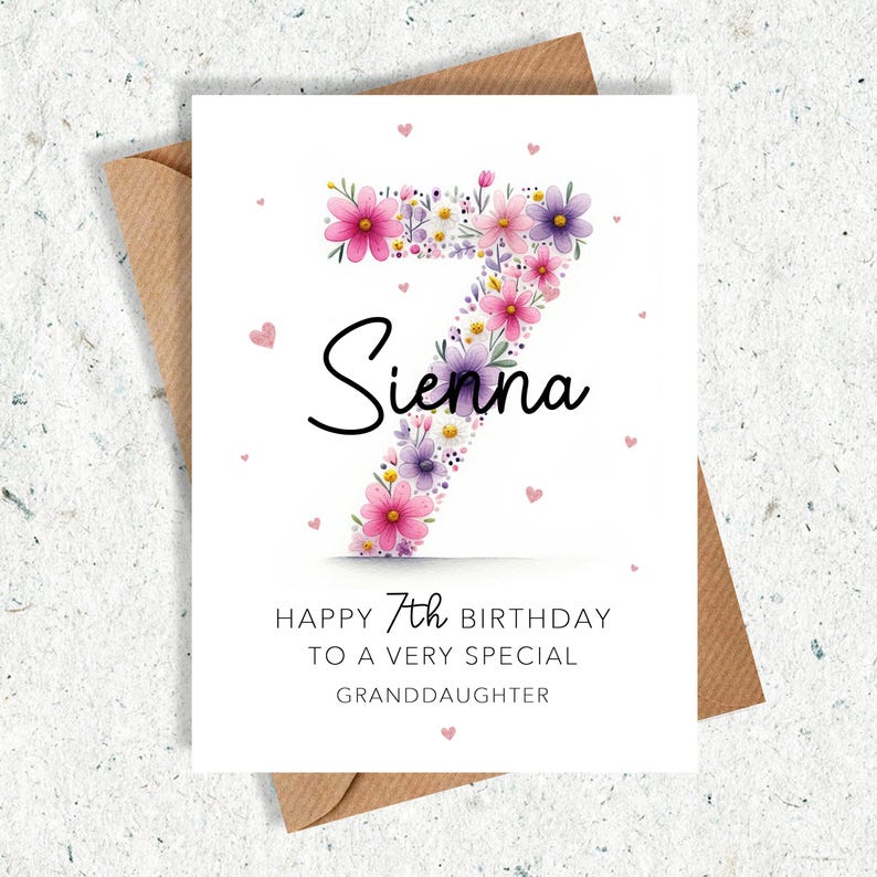 May include: A birthday card with a floral number seven design. The number is filled with pink and purple flowers. The name "Sienna" is written in black script. The card reads "Happy 7th Birthday to a very special granddaughter."