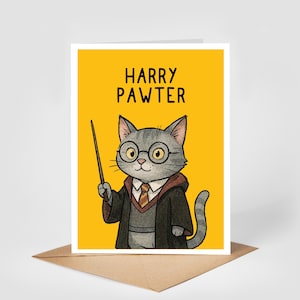 May include: A greeting card with a yellow background and the words "HARRY PAWTER." The illustration shows a grey cat wearing glasses, a tie, and a wizard's robe, holding a wand. The card is on a brown envelope.