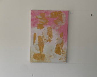Peut inclure: Toile d'art abstrait aux couleurs rose et or. L'œuvre présente un design texturé et superposé avec des formes dorées sur un fond rose. La toile rectangulaire est accrochée à un mur blanc.