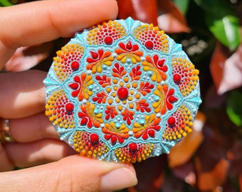 Colorful dot mandala painting on hand painted rock